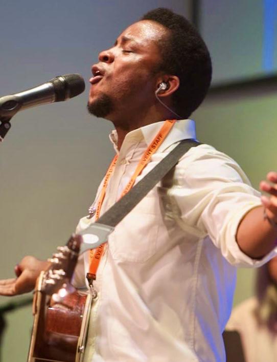 Evangelist Tobi singing and playing guitar